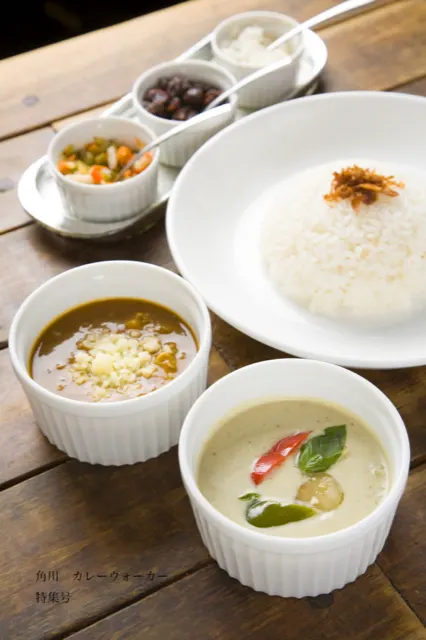 木のテーブルに並ぶスパイシーなカレーセット
