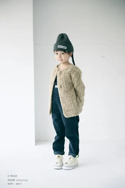 ベージュのニットと帽子でおさげ髪の女の子