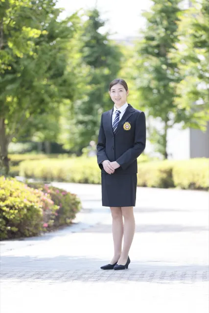 並木道に立つスーツ姿の女性、爽やかな屋外ポートレート