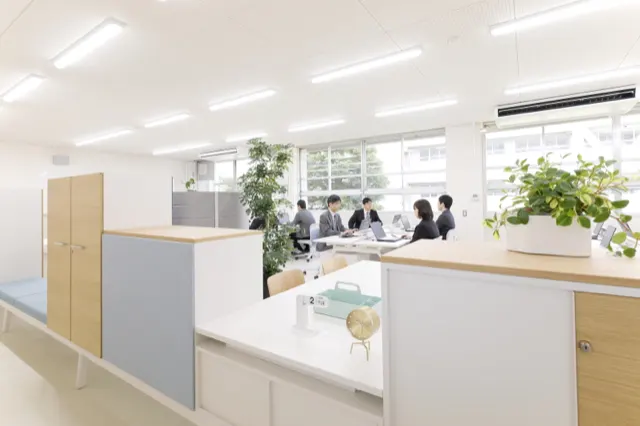 打ち合わせをする人々が写るオープンオフィス